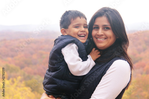 Foto Smiling mother holding son outdoors in the fall