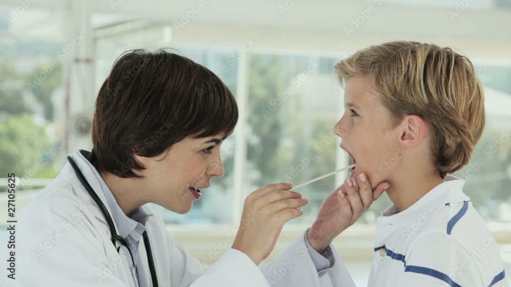 Doctor Looking at the Tonsils of a Young Boy Doctor Looking at the Tonsils of a Young Boy