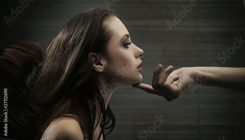 Conceptual image of a hand holding a woman's head