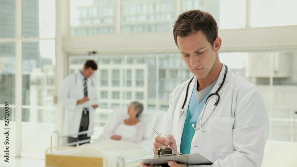 Handsome Young Doctor Smiling in a Hospital Room Handsome Young Doctor Smiling in a Hospital Room