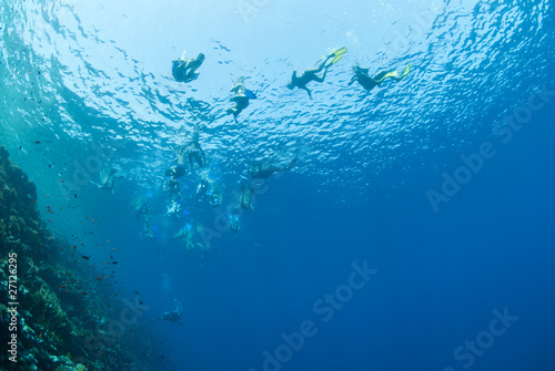 Underwater view of snorkelers at the water surface.
