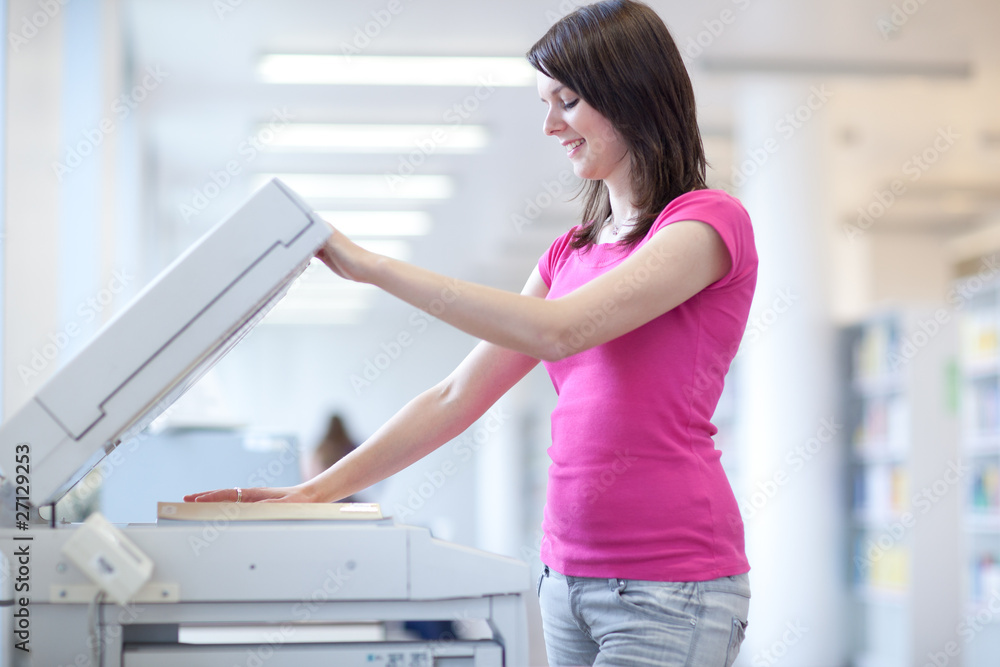 pretty young woman using a copy machine (shallow DOF; color tone pretty young woman using a copy machine (shallow DOF; color tone