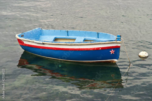 Photo Small, blue rowboat moored in a marina