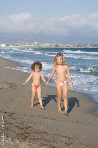 bambine prese per mano sulla spiaggia