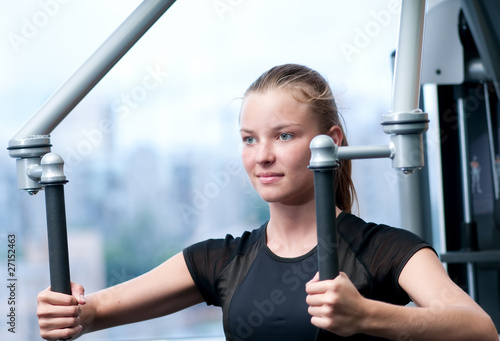 Fotografie Young woman at the gym exercising