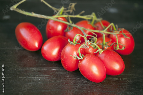 Świeże małe czerwone pomidory na drewnianym stole