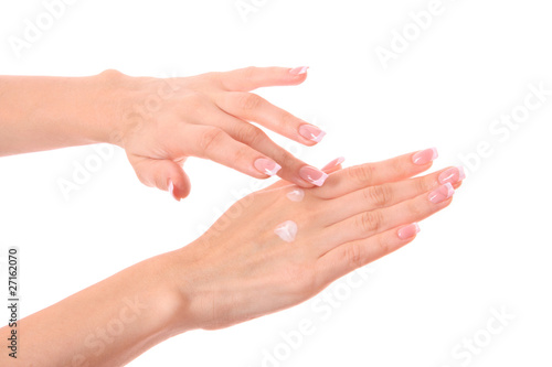 Closeup of beautiful female hands applying hand cream isolated o