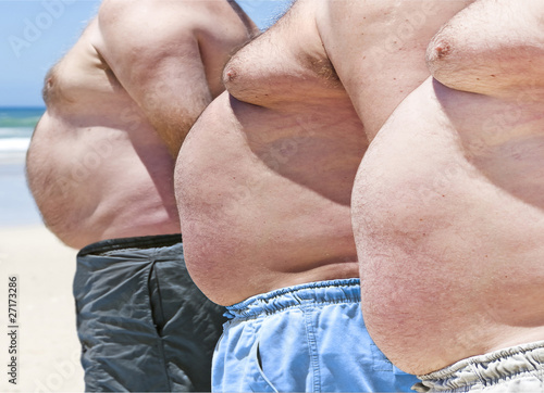 Close up of three obesely fat men on the beach photo