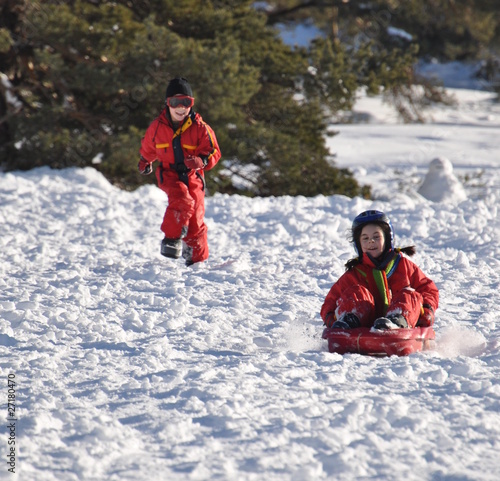 Fotografie sport d'hiver descente d'enfants joyeux en luge