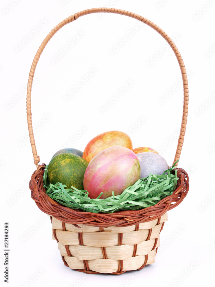 Colored easter eggs in a basket isolated Colored easter eggs in a basket isolated