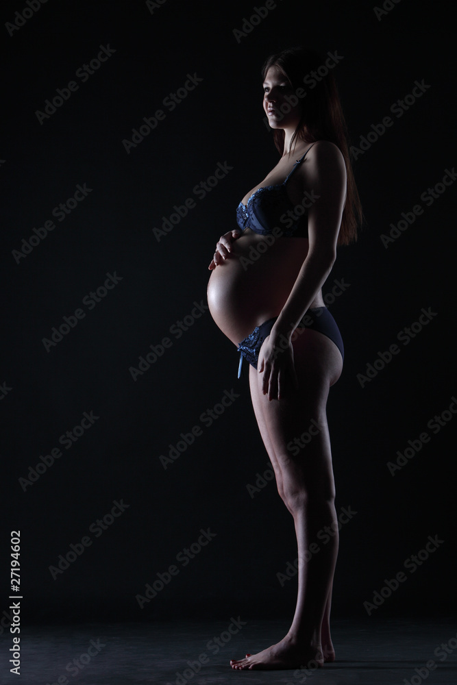 Silhouette of a pregnant woman in the darkness Silhouette of a pregnant woman in the darkness