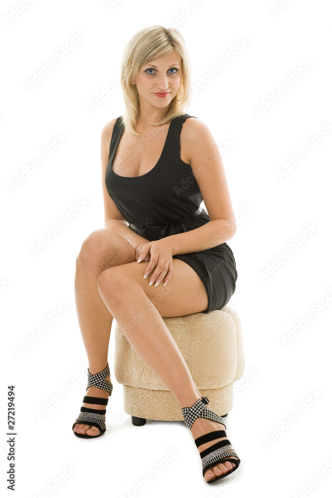 Fototapeta premium Beautiful blonde girl is sitting on an ottoman