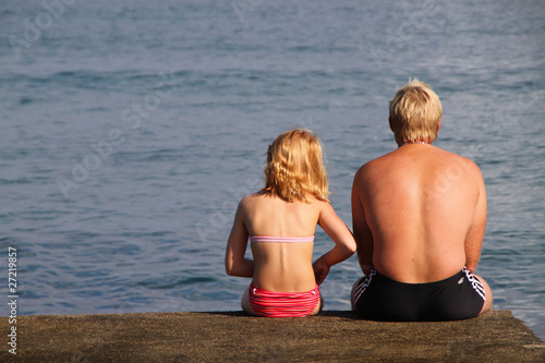 Sehnsucht: Vater und Tochter blicken auf das Meer