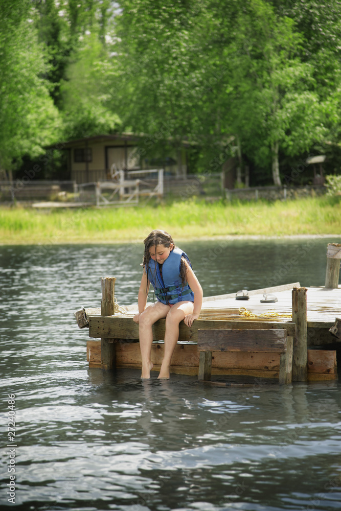 Young Girl Sitting On Dock