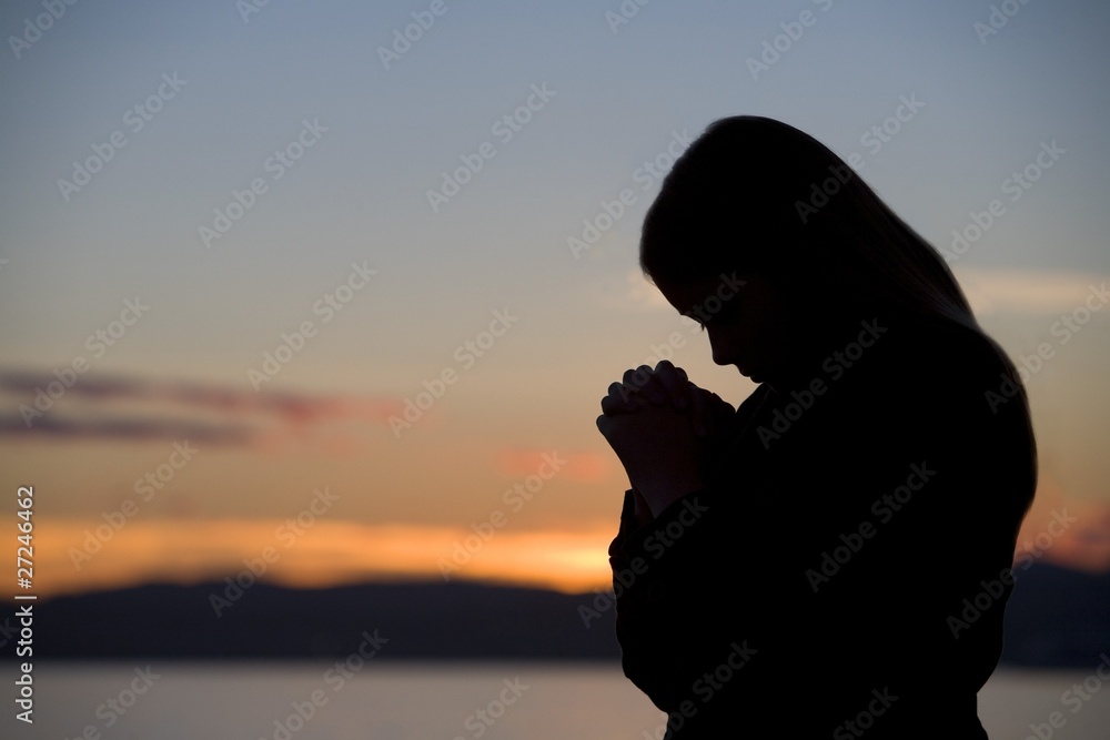 A Teenage Girl Prays At Sunset