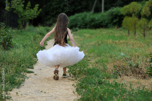 Run away little girl with dark long hair in white tutu skirt