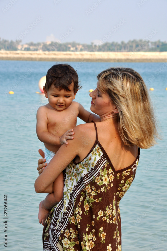 Mother holding her son on hands at beach Mother holding her son on hands at beach