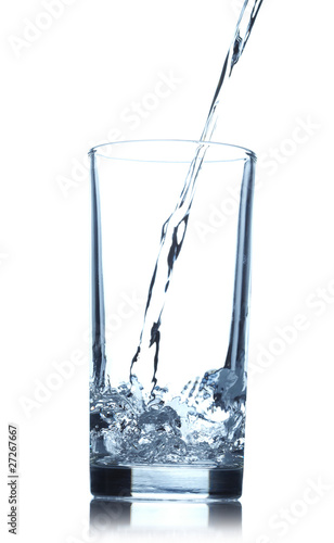 .Pouring water into glass isolated on white background