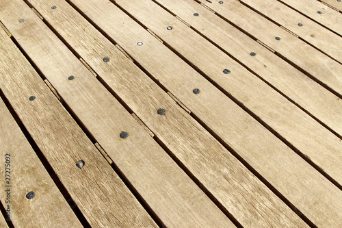 Weathered large wooden decking planks close up.