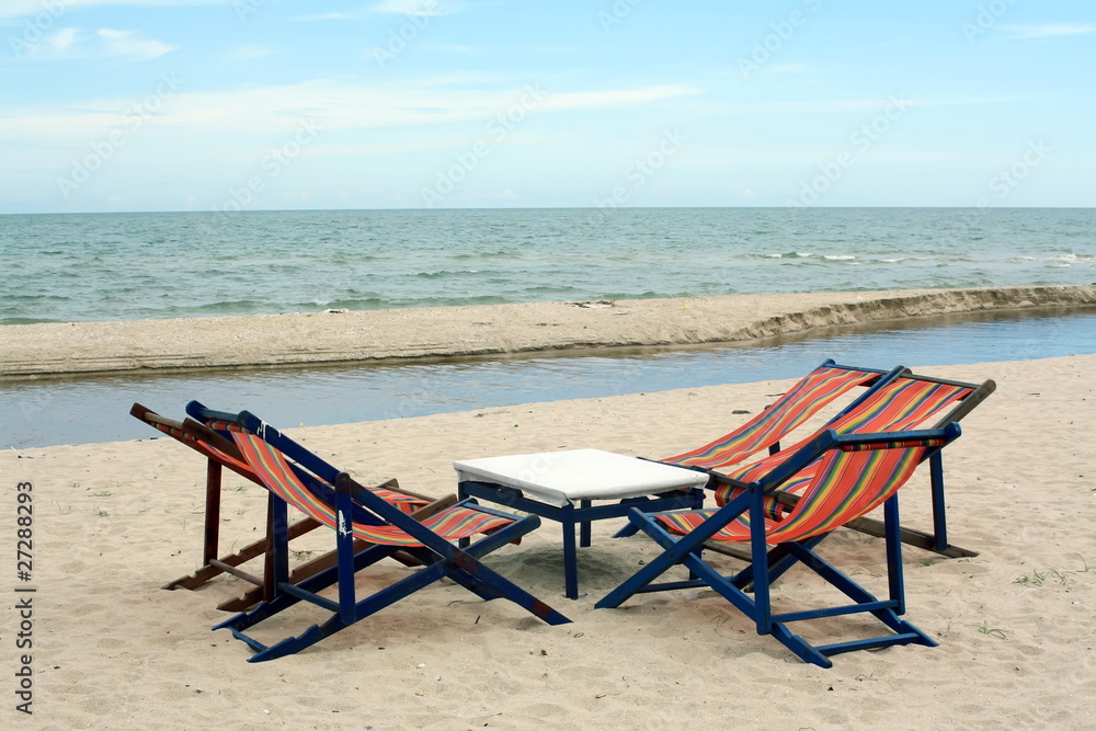 sun beach chairs on shore near sea