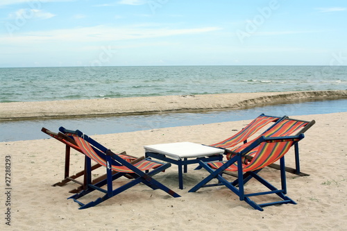 sun beach chairs on shore near sea © phanlop88