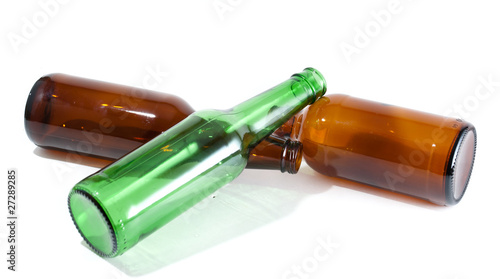 Foto Three empty beer bottles in a pile on isolated background.