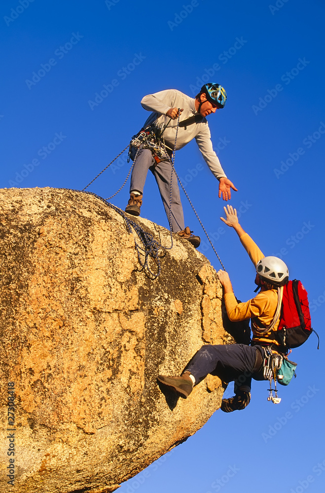 Rock climbing team reaching the summit. StockFoto Adobe Stock