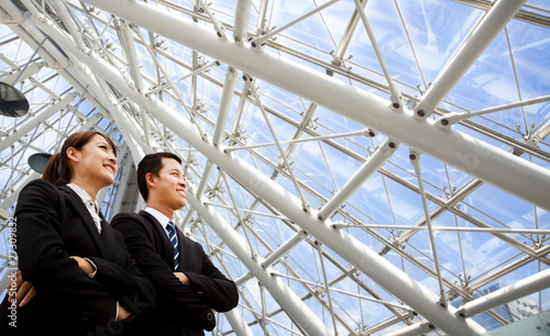 two business people stand in modern office