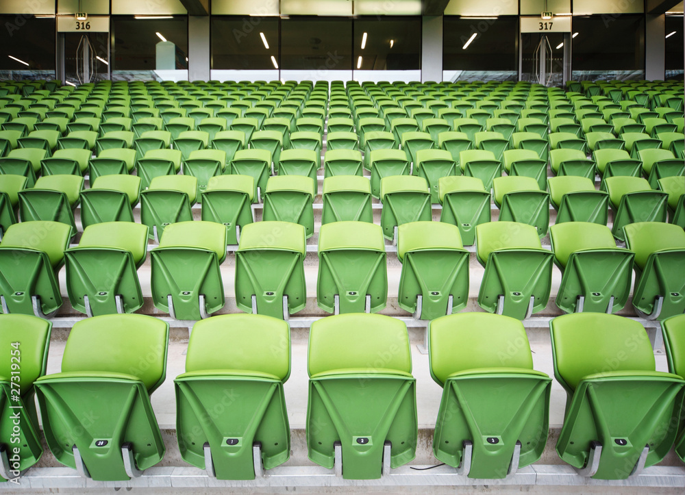 Fototapeta premium Rows of folded seats in empty stadium. Focus on front seats