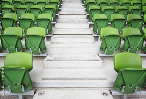 Rows of folded seats in empty stadium. Focus on stairway