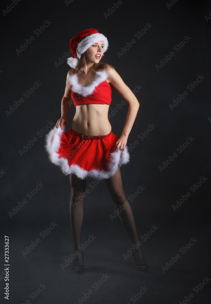 A young and sexy brunette is posing in a Santa suit A young and sexy brunette is posing in a Santa suit