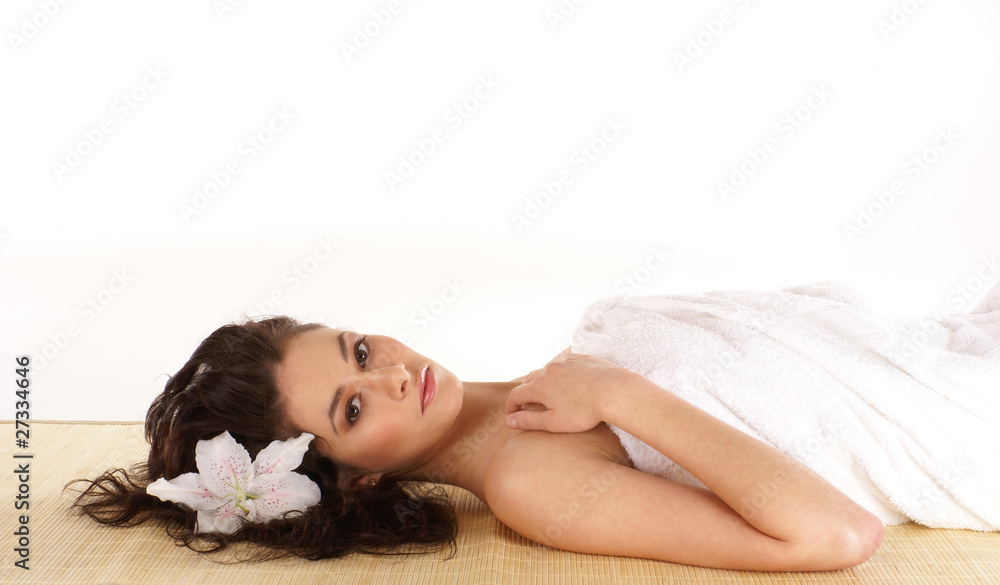 Portrait of a young brunette woman lying on a bamboo mat Portrait of a young brunette woman lying on a bamboo mat