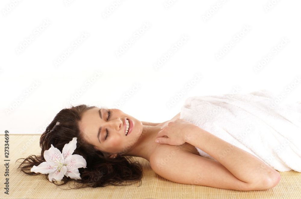 Portrait of a young brunette woman lying on a bamboo mat Portrait of a young brunette woman lying on a bamboo mat