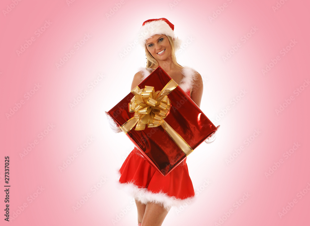 A young blond girl in a Santa costume with a red present A young blond girl in a Santa costume with a red present