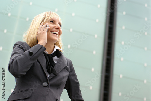 A young and happy blond businesswoman on the phone