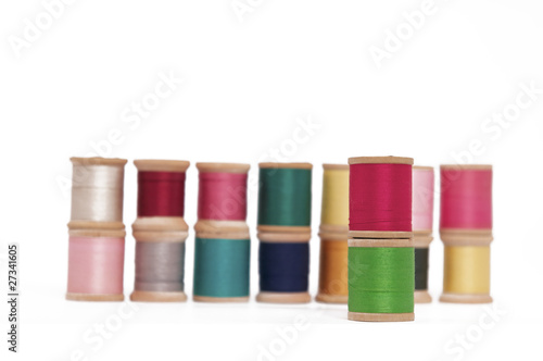 Stacked Spools of Colorful Thread on a White Background