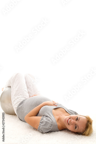 Pregnant woman relaxing on the floor after exercising