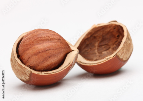 Quadro em tela Close-up of hazelnut in cracked nutshell on white background