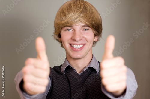 Young casaul man showing his both thumbs up photo