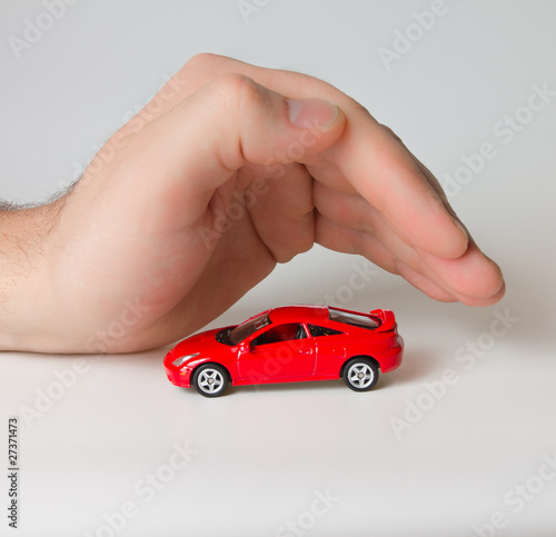 little red sports car under the man's hand