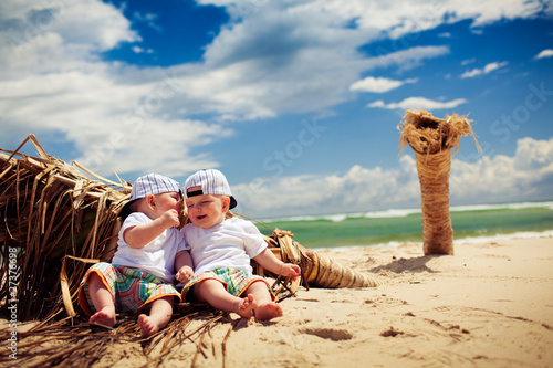 Canvas-taulu identical twin boys relaxing on a beach