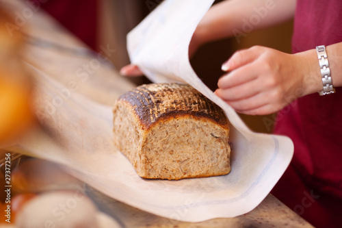 verkäuferin packt leckeres brot ein