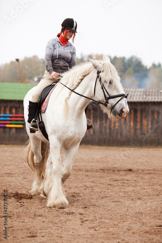 Young woman riding shire horse