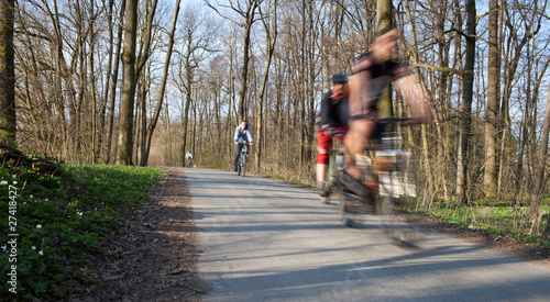 bikers on a biking path in a park (motion blur is used to convey