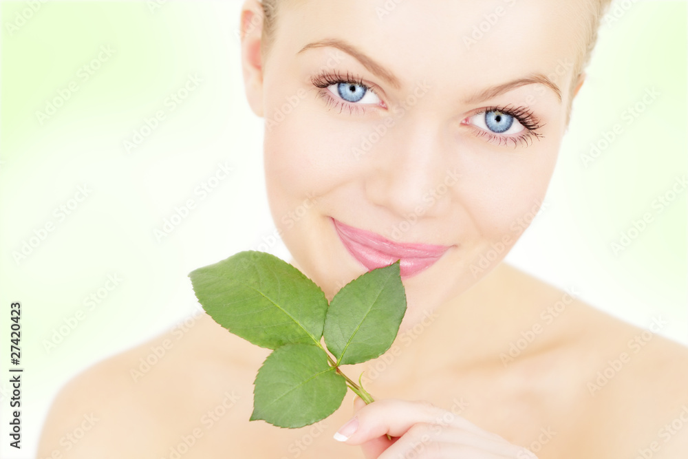 Beautiful girl holding a twig on a light background Beautiful girl holding a twig on a light background