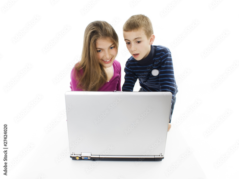 Teenager sister and little brother portrait sitting at notebook