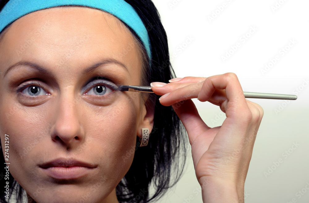 Obraz premium Portrait of beautiful woman applying eye shadow