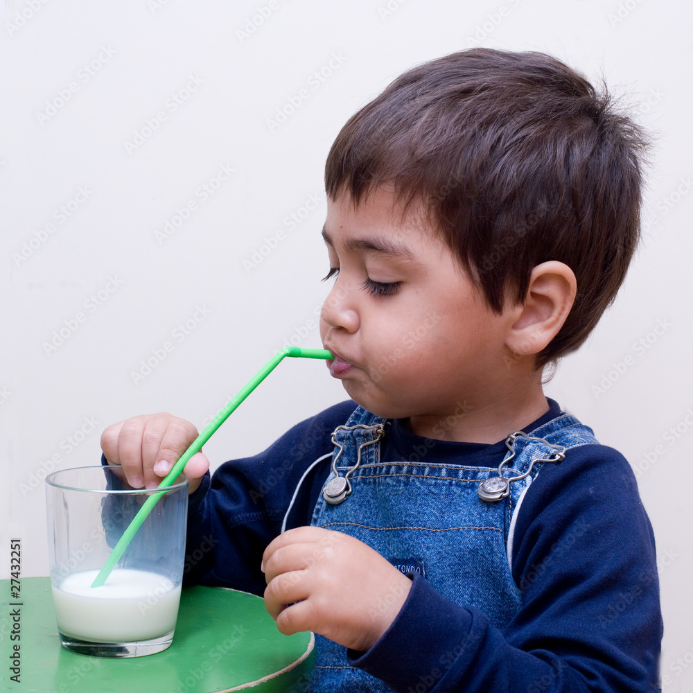 bambino che beve il latte con la cannuccia Stock Photo | Adobe Stock
