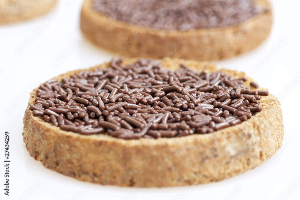 Close up chocolate sprinkles on toast. Close up chocolate sprinkles on toast.
