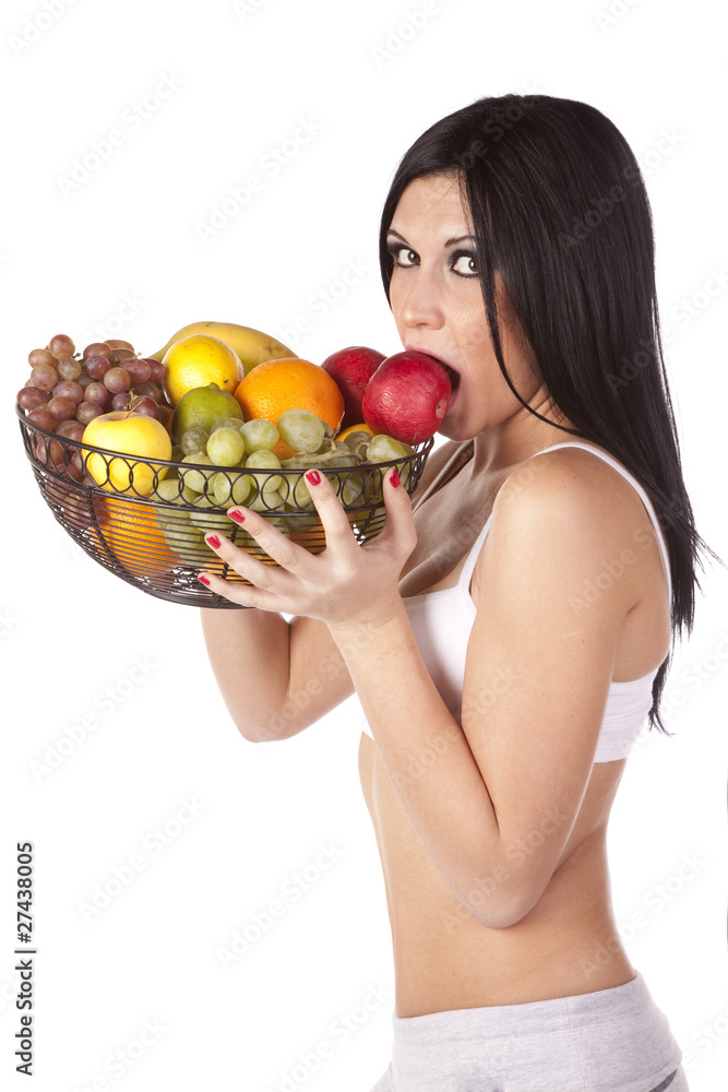 Woman eating apple in fruit basket Woman eating apple in fruit basket